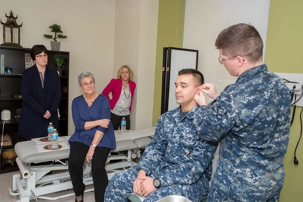 soldier applying bfa to another soldier with family watching