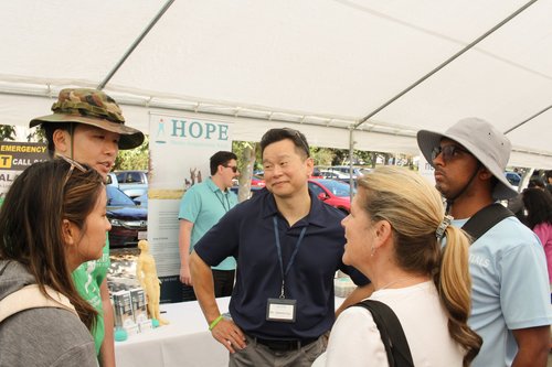 Dr. Lu speaking with attendees at HOPE Clinic community outreach booth