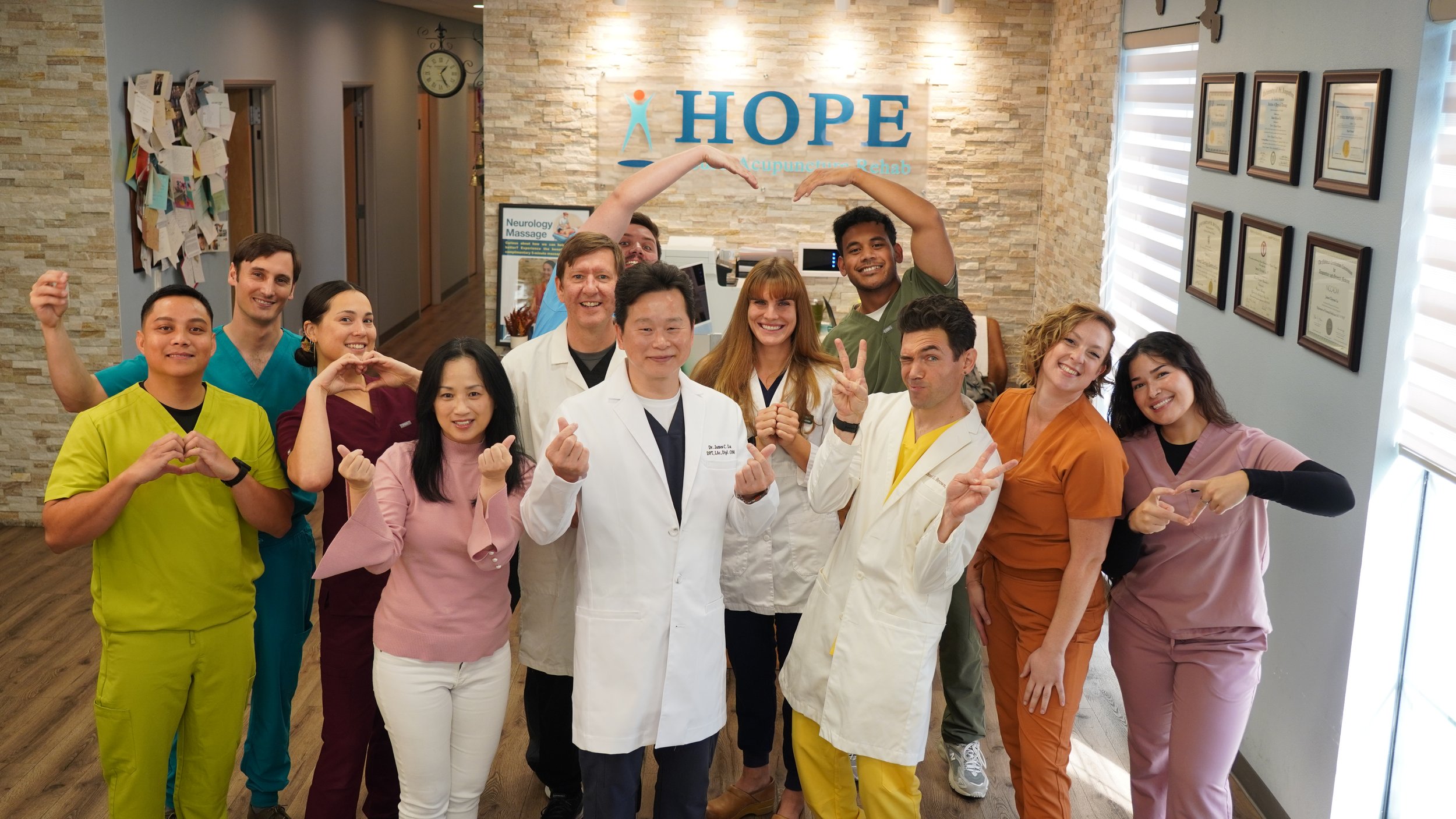 HOPE Clinic team making heart shapes with hands in group photo in lobby
