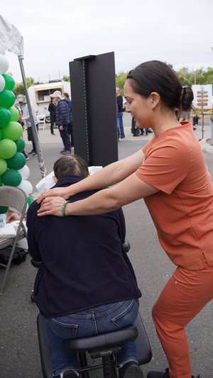 HOPE therapist providing seated back massage to attendee at community event