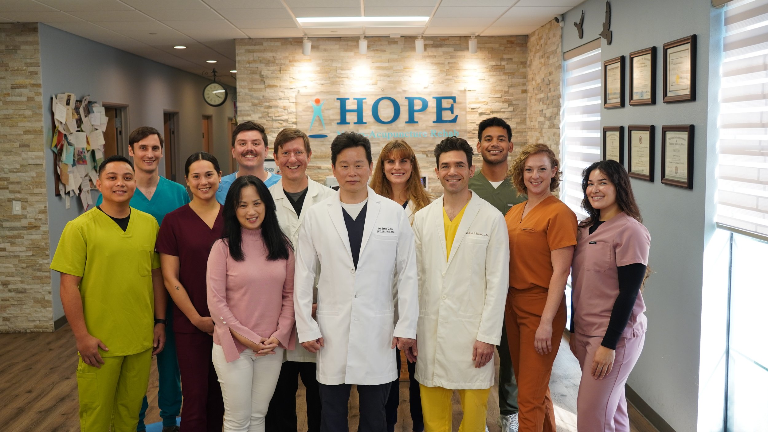 Full HOPE Clinic team professional group photo in lobby with Dr. Lu in white coat