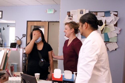 Candid moment between patient and therapy team in clinic break room