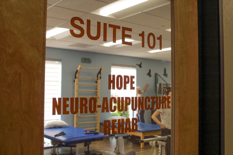 Dr. Lu and staff member posing with patient at clinic front desk