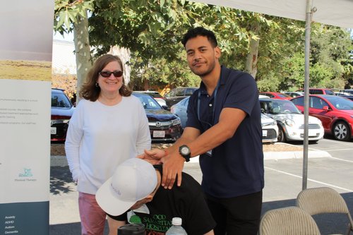 HOPE Clinic therapist demonstrating hand therapy to community member at outreach event