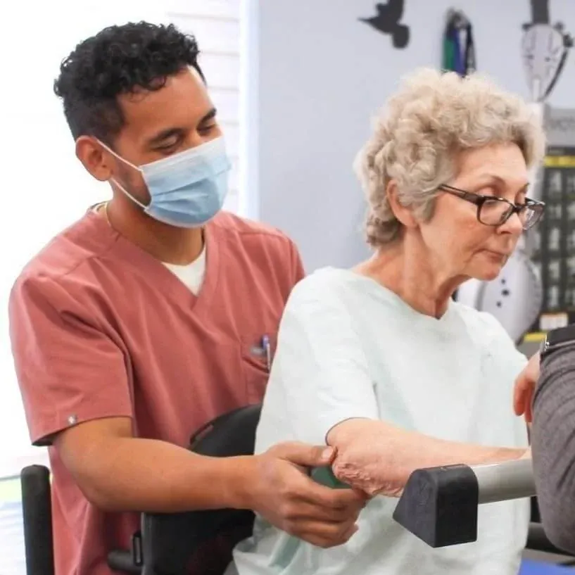 Physical therapy aid helping patient walk during stroke rehabilitation