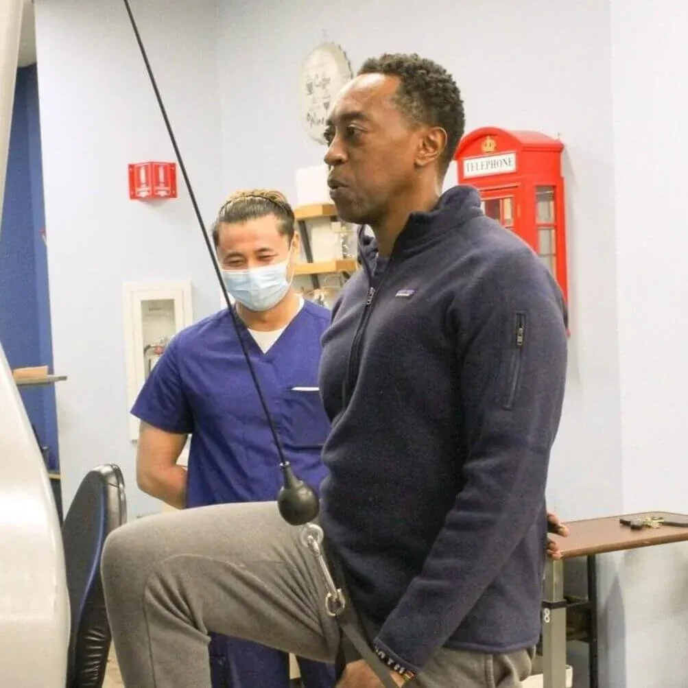 Man working out with physical therapist aid